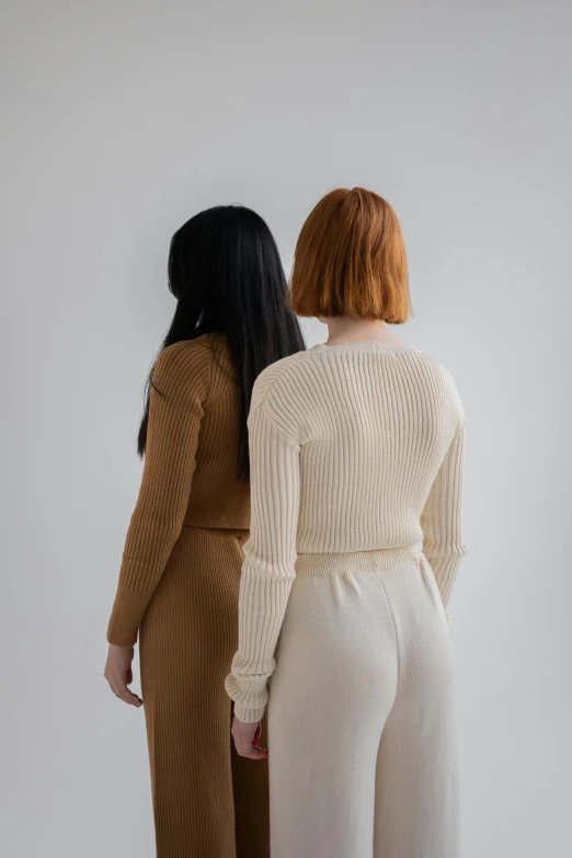 a couple of women standing next to each other, inspired by Vanessa Beecroft, trending on pexels, renaissance, brown sweater, white background, bum, asian women