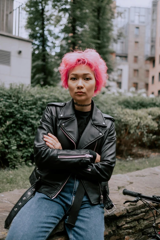 a woman with pink hair sitting on a rock, trending on pexels, antipodeans, dressed in biker leather, gemma chen, proud serious expression, view from the streets