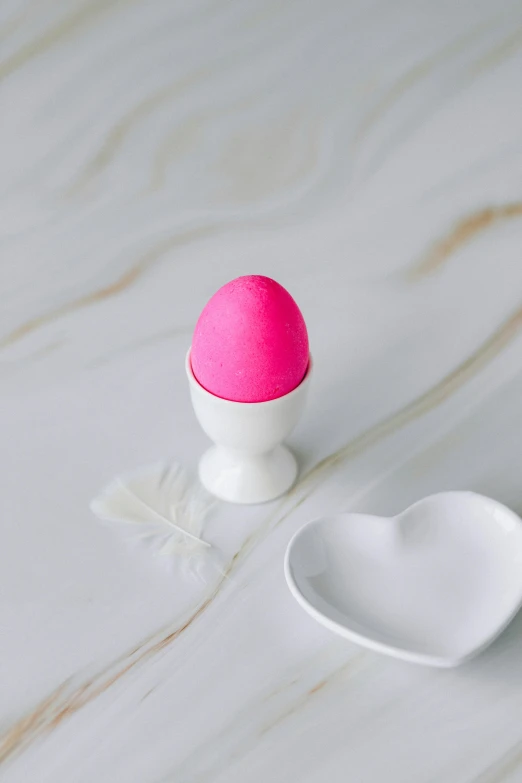 a pink egg sitting on top of a white plate, matte finish, cupid, product shot, a brightly colored