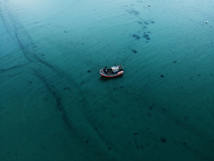 a small boat in the middle of a large body of water, pexels contest winner, dredged seabed, cornwall, not a messenger from above, dark dingy