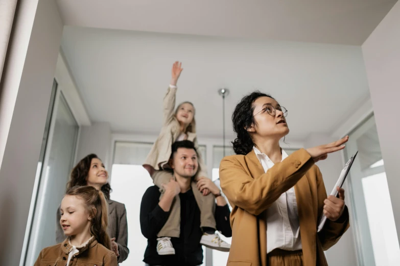 a group of people standing in a room, female ascending into the sky, family friendly, very professional, pointing