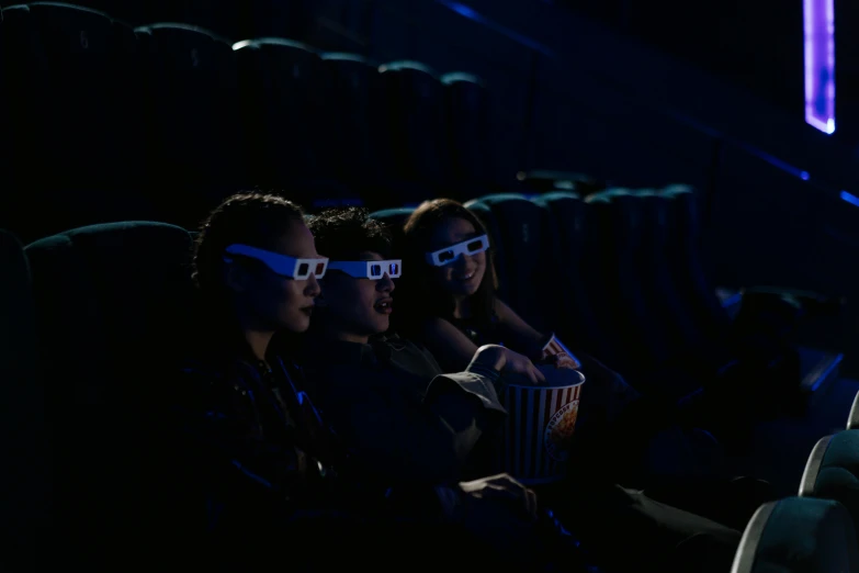 a group of people sitting in a theater wearing 3d glasses, a hologram, pexels, hyperrealism, avatar image, film key art, (night), mid-shot