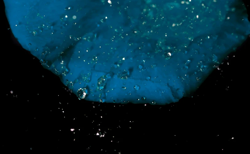 a close up of a blue object on a black background, a microscopic photo, pexels, bubbles rising, cavern ceiling visible, blue liquid and snow, teal color graded