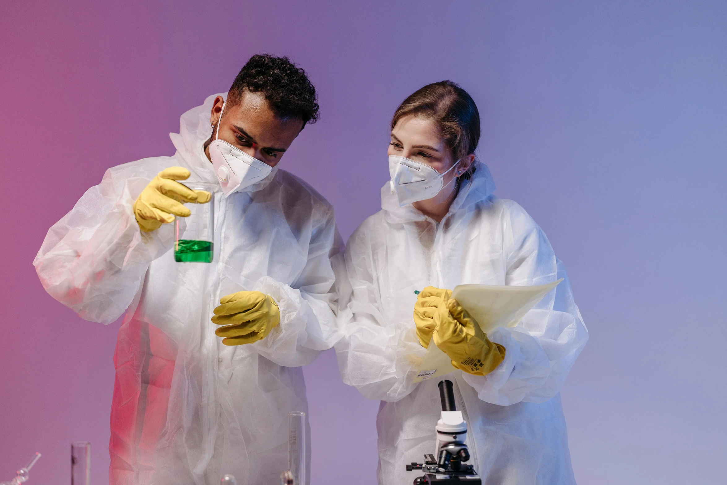 a couple of people standing in front of a microscope, trending on pexels, staff wearing hazmat suits, wearing gloves, thumbnail, studio photo