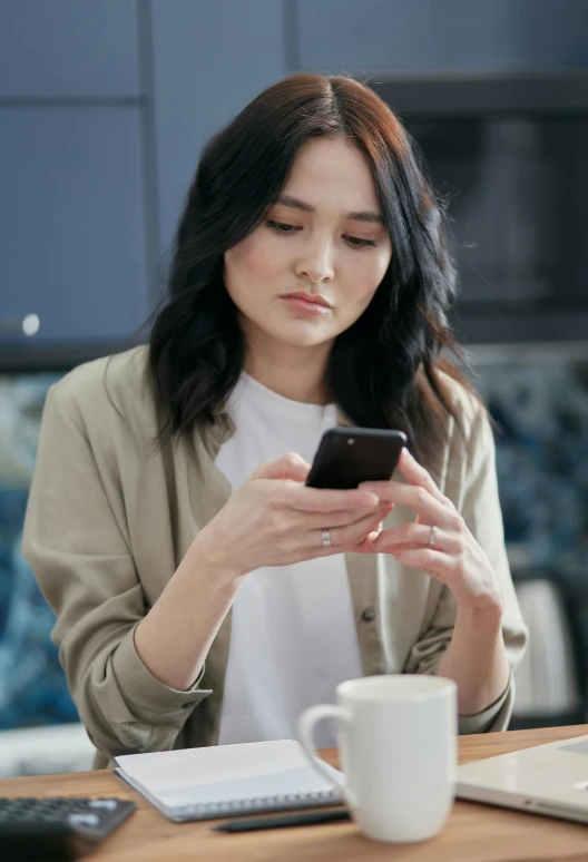 a woman sitting at a table looking at her cell phone, trending on pexels, renaissance, young asian woman, avatar image, grey, brown