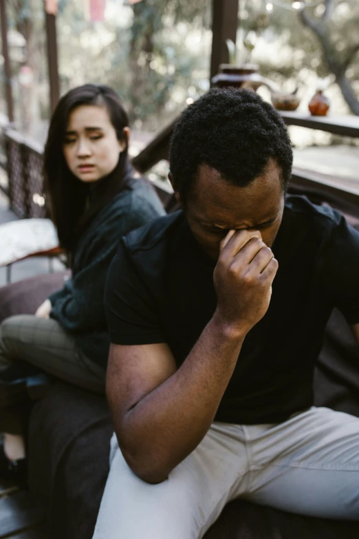 a man and a woman sitting on a bench, stressing out, man is with black skin, damaged, mental health