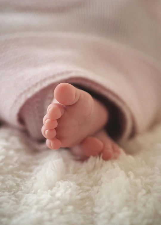 a close up of a baby's feet on a blanket, by Lilia Alvarado, pexels, photorealism, soft light 4 k in pink, medium format. soft light, ilustration, soft light - n 9