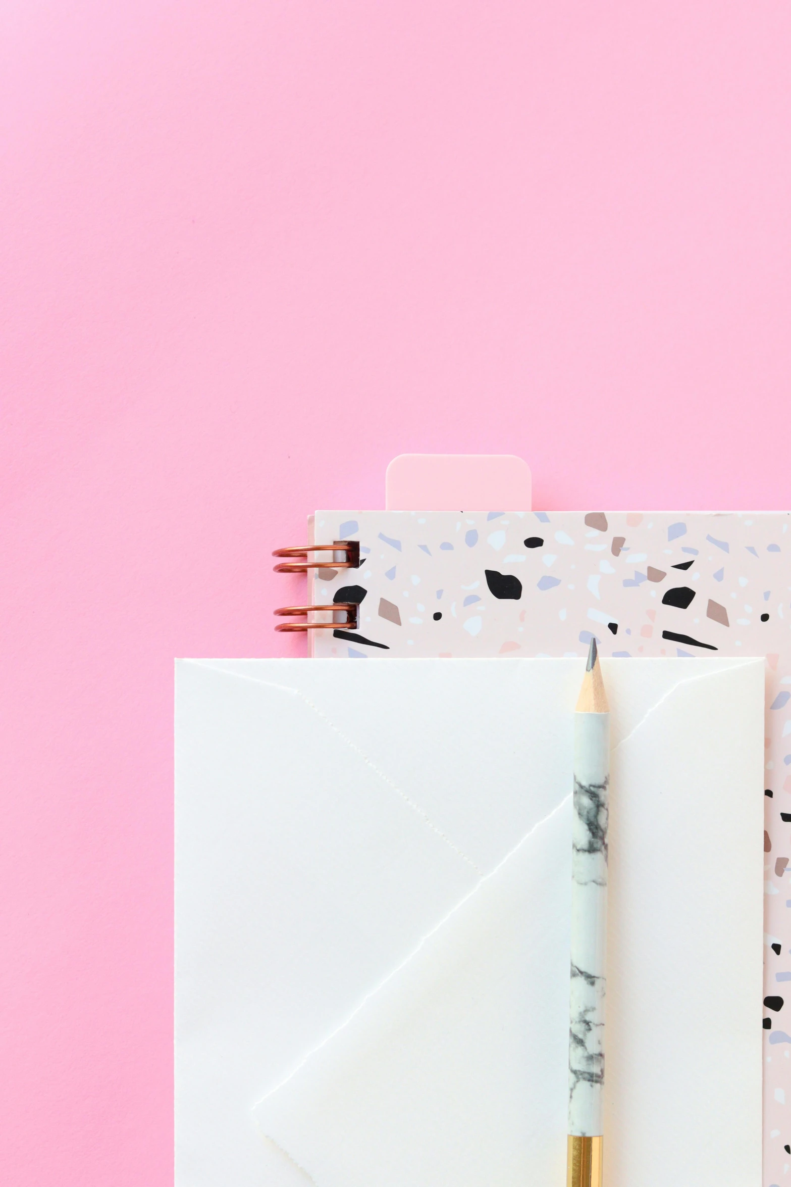 a notepad with a pencil sitting on top of it, by Julia Pishtar, pink scheme, middle close up, terrazzo, whiteboards