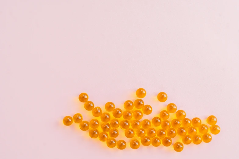 fish oil capsules on a white background, by Emma Andijewska, pexels, digital art, light orange mist, bubblegum, beads, minimalistic composition