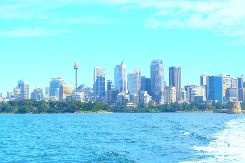 a large body of water with a city in the background, inspired by Sydney Carline, hurufiyya, clear blue skies, the photo was taken from a boat, light blue clear sky, 4k photo”