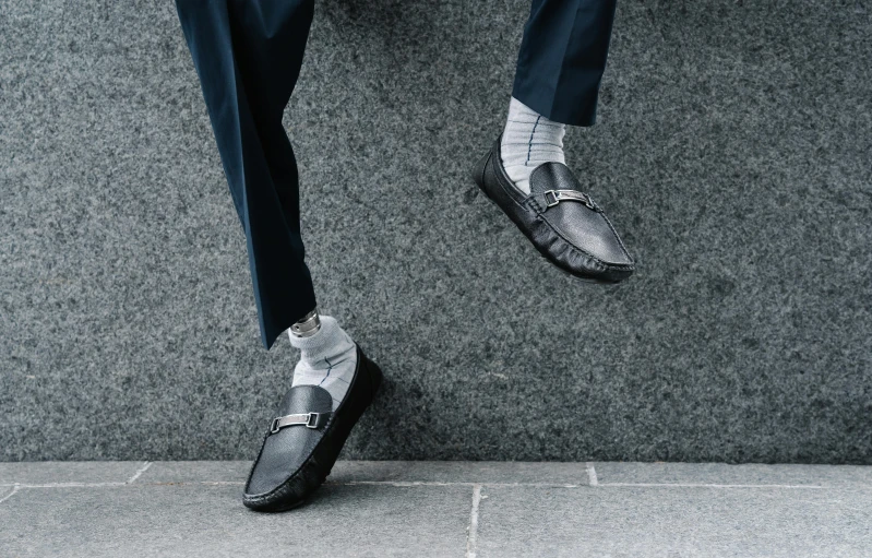 a close up of a person wearing a suit and shoes, slippers, grey pants and black dress shoes, top down, engineered