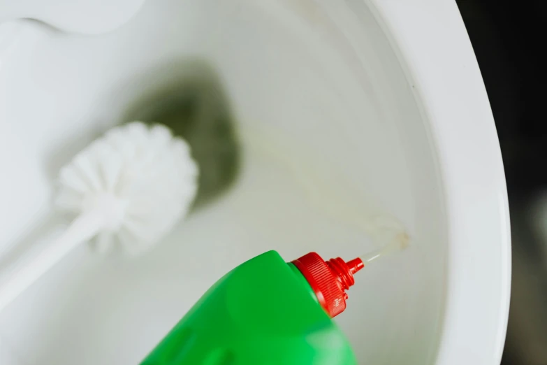 a bottle of toilet cleaner sitting inside of a toilet, by Nicolette Macnamara, pexels contest winner, green and red, low detail, profile image, shot on sony a 7