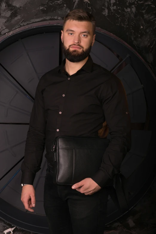 a man in a black shirt holding a black bag, in a dark futuristic room, holding a leather purse, khyzyl saleem, official product image