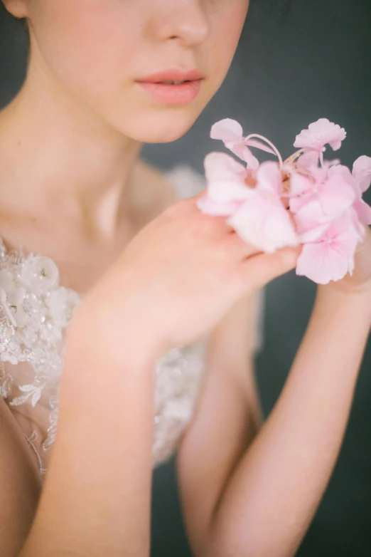 a woman with a flower in her hand, inspired by Cecil Beaton, unsplash, romanticism, delicate pale pink lips, soft elegant gown, orchids, close up half body shot