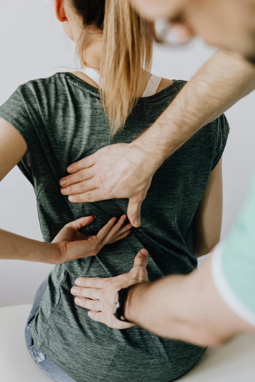 a man helping a woman with her back pain, a colorized photo, by Adam Marczyński, pexels contest winner, wearing tight shirt, scaly, medical reference, close up to a skinny