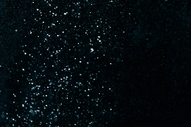 a man riding a snowboard down a snow covered slope, an album cover, by Adam Marczyński, pexels, conceptual art, black sky full of stars, water bubbles, dots abstract, solid black #000000 background