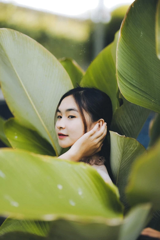 a woman sitting on top of a lush green plant, inspired by Ren Hang, trending on pexels, exotic lily ears, headshot profile picture, vietnamese woman, multiple stories