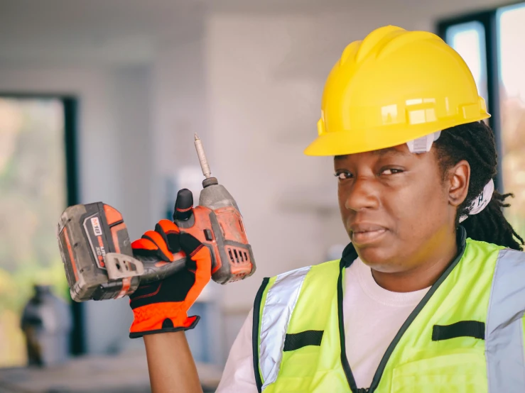 a woman in a hard hat holding a drill, pexels contest winner, black man with afro hair, wearing hi vis clothing, thumbnail, reconstruction