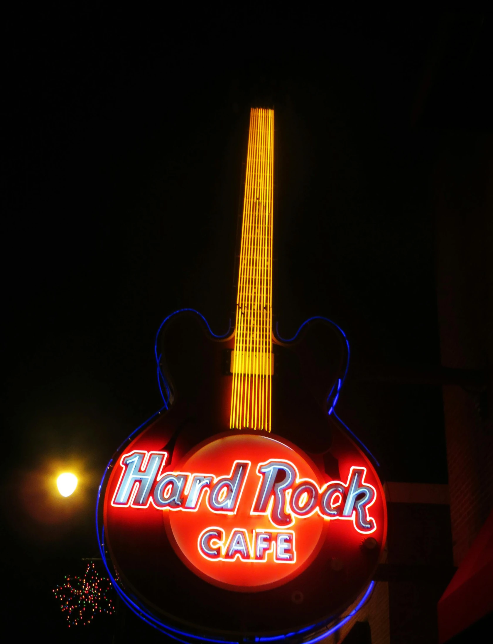 a neon sign that says hard rock cafe, by Jesse Richards, ((rocks)), trending photo, long shot from back, memphis