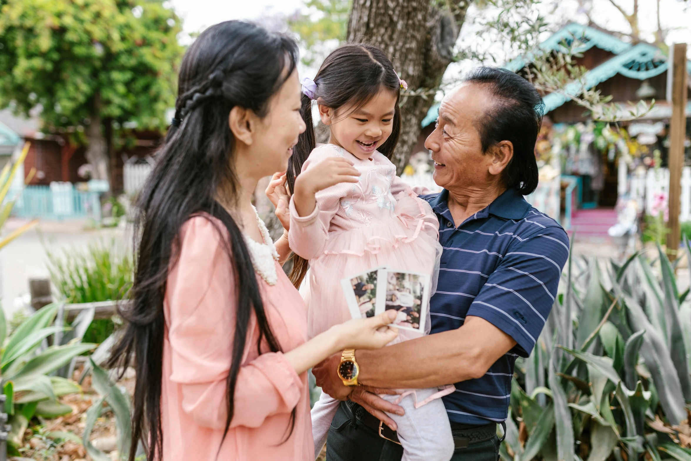 a woman standing next to a man holding a little girl, pexels contest winner, happening, avatar image, asian descent, holding gift, colour photograph