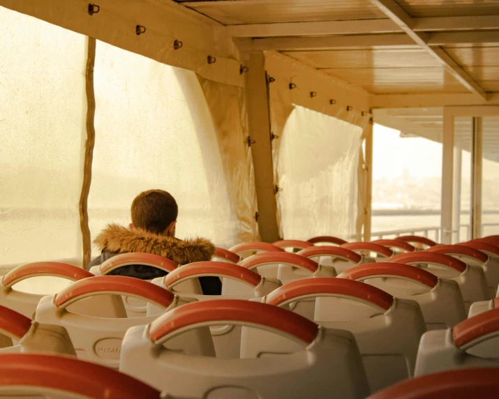 a person sitting on a bus looking out the window, on a boat, back view. nuri iyem, rex orange county, in egypt