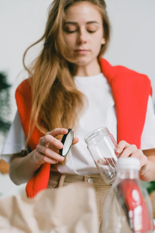 a woman is pouring water into a glass, by Julia Pishtar, trending on pexels, wearing red jacket, salt shaker, scanning items with smartphone, gif