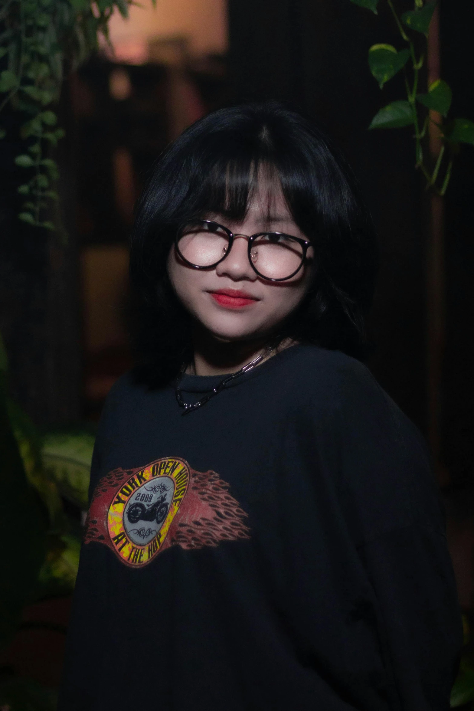 a woman with glasses posing for a picture, an album cover, inspired by Ruth Jên, pexels contest winner, realism, wearing a black t-shirt, ruan cute vtuber, (night), kuntilanak