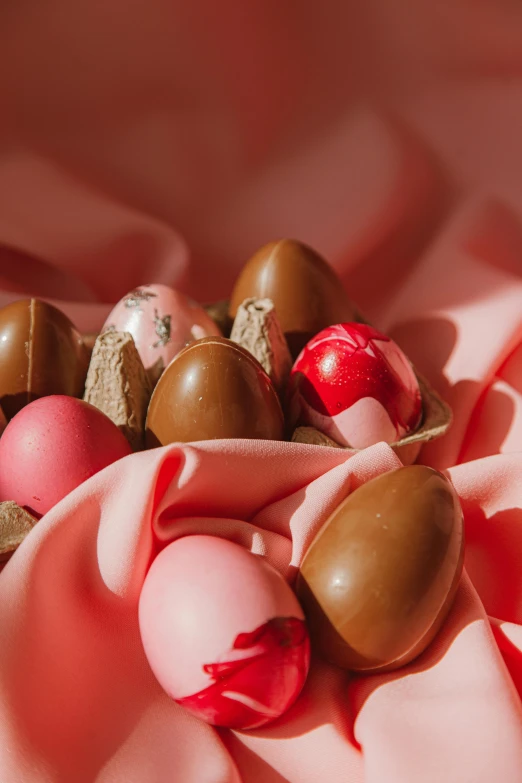 a bunch of chocolate eggs sitting on top of a pink cloth, pink and pink details, warm coloured, super smooth, manuka