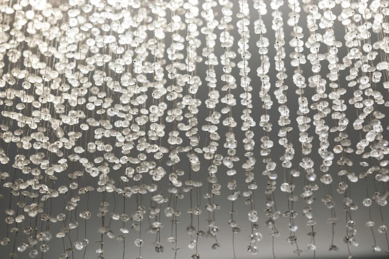 a close up of a chandelier hanging from a ceiling, an album cover, inspired by Bruce Munro, kinetic pointillism, silver，ivory, detail shot, demur, drops