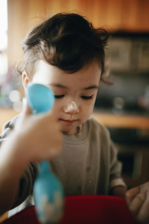 a little boy that is sitting at a table, thumbnail, holding maracas, in a kitchen, soft shapes