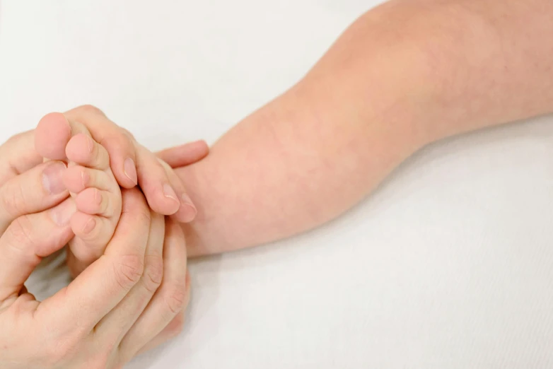 a close up of a person holding a child's hand, nerves and muscles, local conspirologist, manuka, smooth light from upper left