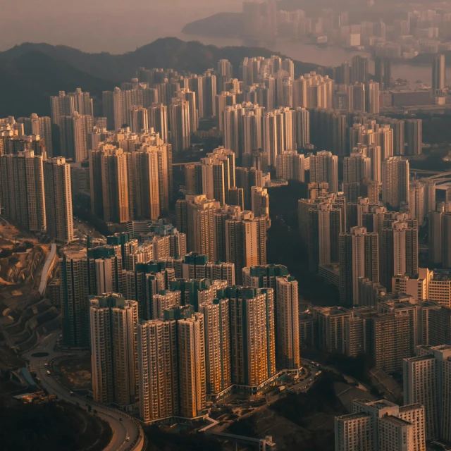 an aerial view of a city with lots of tall buildings, by Patrick Ching, pexels contest winner, hyperrealism, hills, hard morning light, settlement, [ cinematic