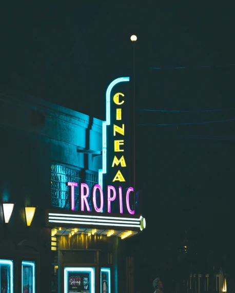 a movie theater marquee lit up at night, trending on unsplash, tropics, cinematic outfit photo