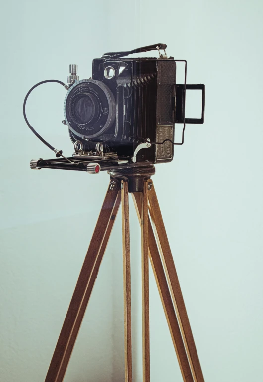 a camera sitting on top of a wooden tripod, inspired by August Sander, photorealism, 155 cm tall, brown, medium format