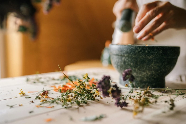 a person mixing flowers in a bowl on a table, by Carey Morris, trending on pexels, dried herbs, chefs table, on a marble pedestal, pestle