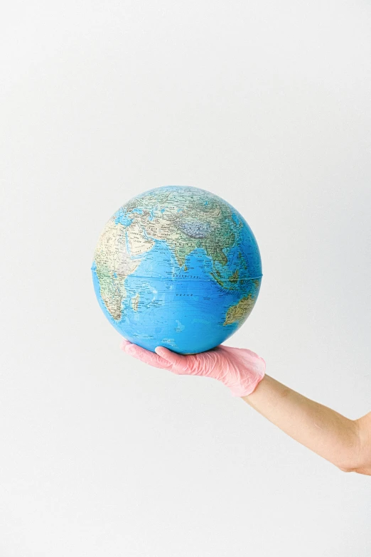 a woman in pink gloves holding a blue globe, by Alison Geissler, pexels, plasticien, surgical supplies, varying ethnicities, 🚿🗝📝