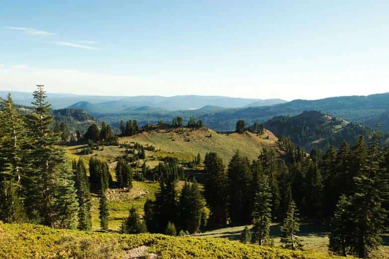 a man riding a horse on top of a lush green hillside, by Jessie Algie, unsplash, renaissance, crater lake, black fir, panorama distant view, late summer evening