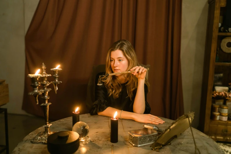 a woman sitting at a table with candles in front of her, pexels contest winner, magic realism, sydney sweeney, holding a sacrificial dagger, a magician's chamber, profile image