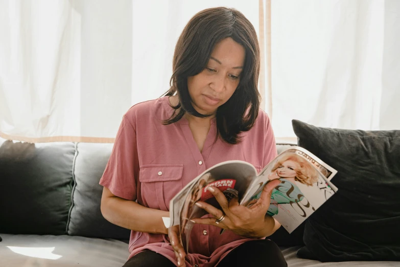 a woman sitting on a couch reading a magazine, a cartoon, pexels contest winner, joanna gaines, riyahd cassiem, editorial footage, looking to the side