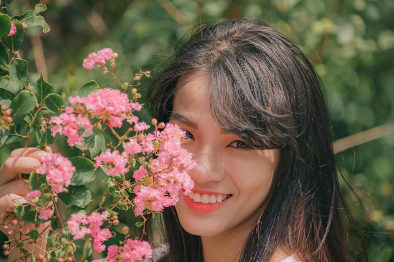 a woman holding a pink flower in front of her face, inspired by Kim Jeong-hui, pexels contest winner, smiling girl, profile image, slightly tanned, with flowers and plants