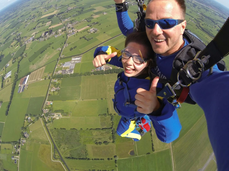 a man and a little girl on a parachute, dutch angle from space view, highly upvoted, man in dark blue full body suit, thumbnail