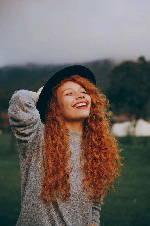 a woman with long red hair wearing a hat, trending on pexels, dark short curly hair smiling, teenage girl, excited, instagram post