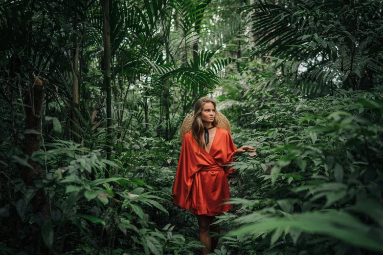 a woman in a red robe standing in a forest, by Emma Andijewska, sumatraism, lush jungle, nina agdal, avatar image