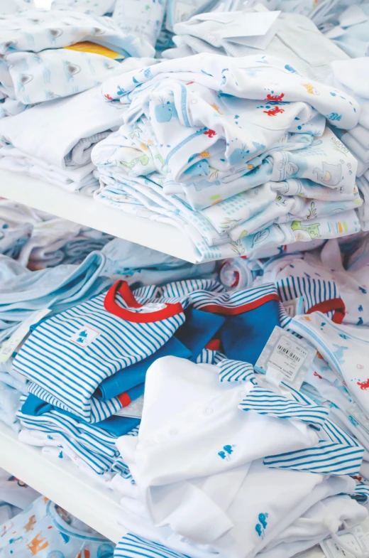 a pile of baby clothes sitting on top of a table, blue and white and red mist, collection product, multiple stories, low detail