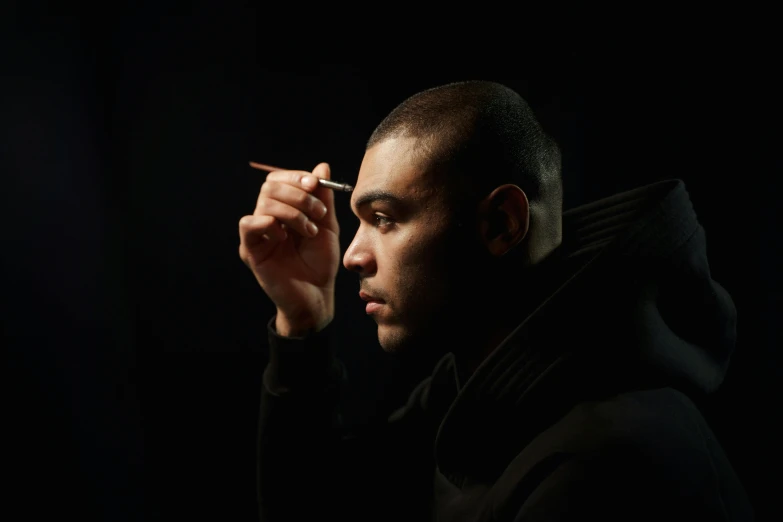 a man smoking a cigarette in the dark, inspired by Theo Constanté, buzz cut hair, holding pencil, saadane afif, portrait photograph