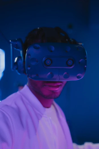 a man wearing a virtual reality headset in a room, brightly lit blue room, afro tech, intense look, stood in a lab