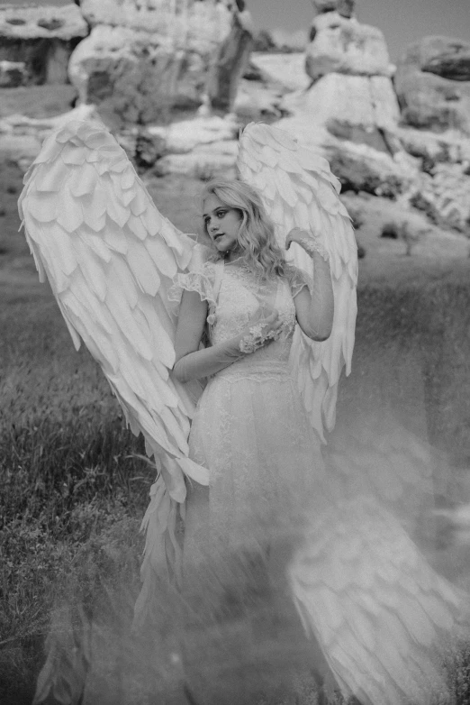 a black and white photo of an angel, magical realism, fairycore, big white glowing wings, evanna lynch, in style of petra collins