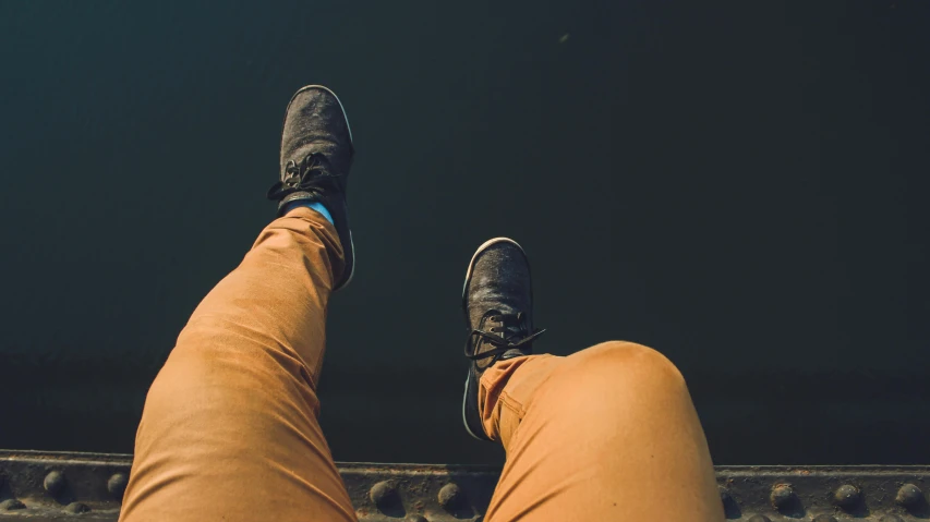 a person standing on top of a train track, pexels contest winner, trout in pants, on a boat, detailed shot legs-up, sitting down casually