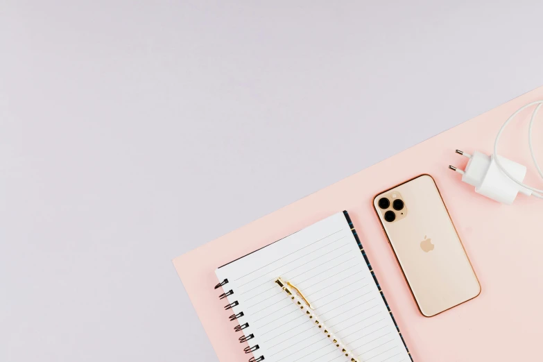 a notebook, headphones, and an iphone on a pink surface, trending on pexels, minimalism, background image, thin gold details, thumbnail, professional iphone photo
