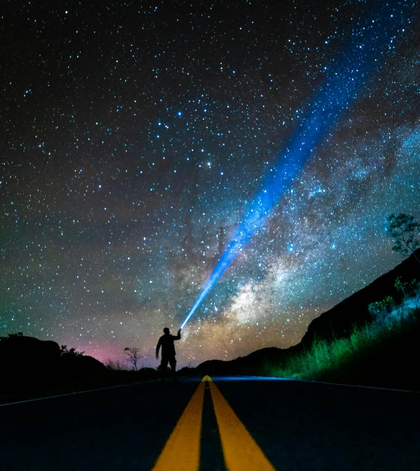 a person standing in the middle of a road under a sky full of stars, a hologram, pexels contest winner, light and space, blue light saber, earth seen on the dark sky, avatar image, the james webb telescope